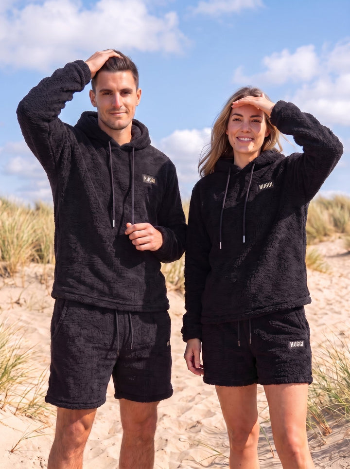 Two friends wearing the Black Huggi Fleece Two-Piece Set on the beach dunes model: Emma is 5&